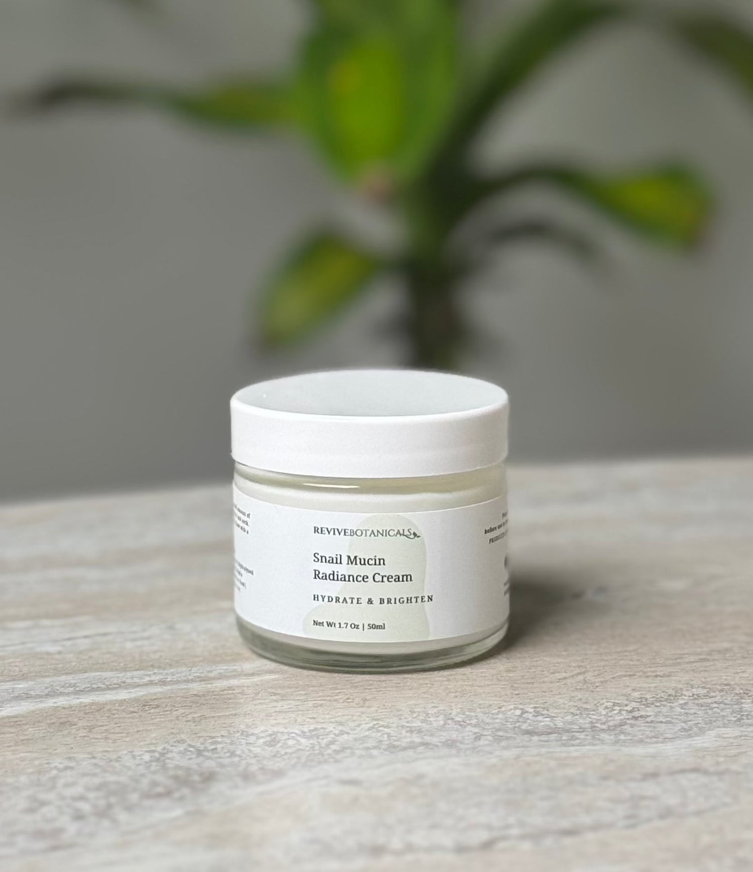 Snail Mucin Radiance Cream jar on a table, skincare moisturizer for hydration and glow.