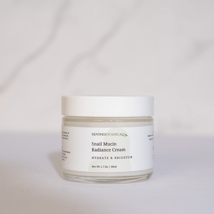 Snail Mucin Radiance Cream jar on a marble surface, promoting hydration, brightness, and skin smoothing.