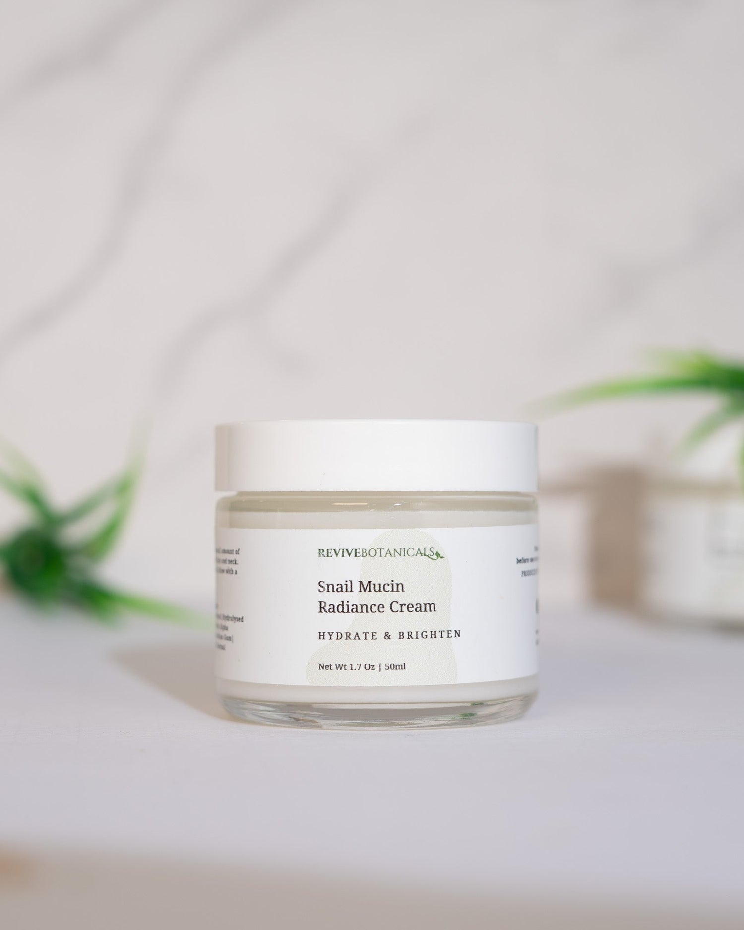 Snail Mucin Radiance Cream in a white jar with a minimalistic design for hydrated and radiant skin.