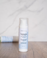 Acne & Dark Spots Face Cream bottle on a wooden surface.